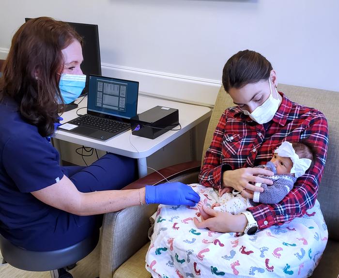 Doctor, mother and baby using the device