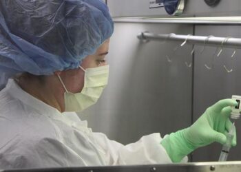 UHS pharmacy technician Katie Sasina draws a syringe in the pharmacy's sterile compounder.