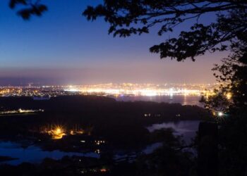 Street lighting creates an artificial glow in the night sky above Plymouth, UK