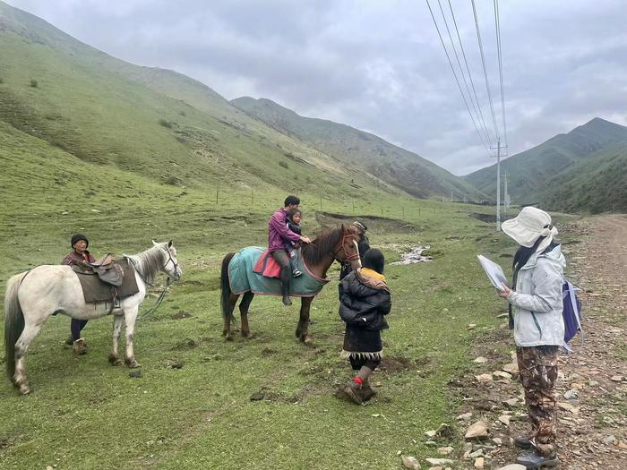 Pastoralists on horseback being interviewed by researchers