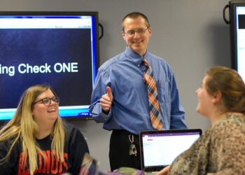 David Rosch in a classroom with two students.