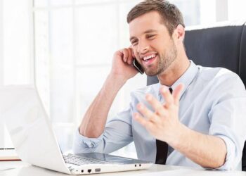 Man at computer and talking on phone