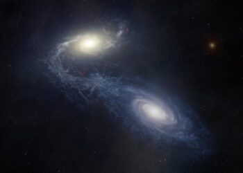Giant spiral galaxy NGC 1365 merging with another galaxy