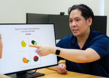 Assistant Professor Steven Pan (right) and Ms Tabitha Chua (seen in profile) with a reproduction of a guessing-with-feedback learning method found in language apps. (A) Learners first guess the Spanish word using images and words. (B) Correct answer feedback is provided after an incorrect guess, or (C) Affirmative feedback is provided after a correct guess.