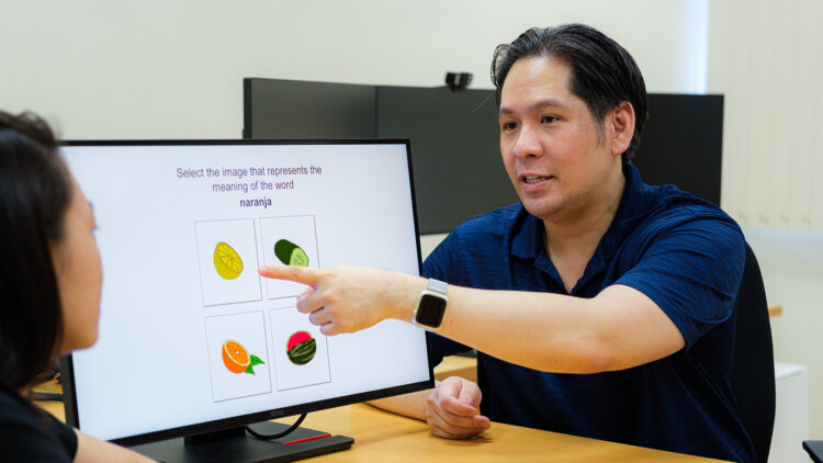 Assistant Professor Steven Pan (right) and Ms Tabitha Chua (seen in profile) with a reproduction of a guessing-with-feedback learning method found in language apps. (A) Learners first guess the Spanish word using images and words. (B) Correct answer feedback is provided after an incorrect guess, or (C) Affirmative feedback is provided after a correct guess.